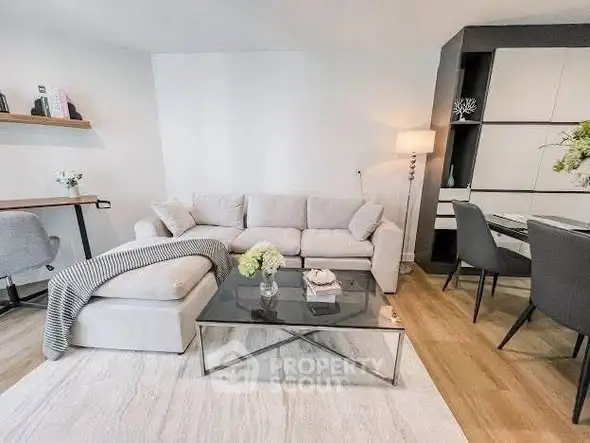 Modern living room with stylish furniture and elegant decor, featuring a cozy sofa and glass coffee table.