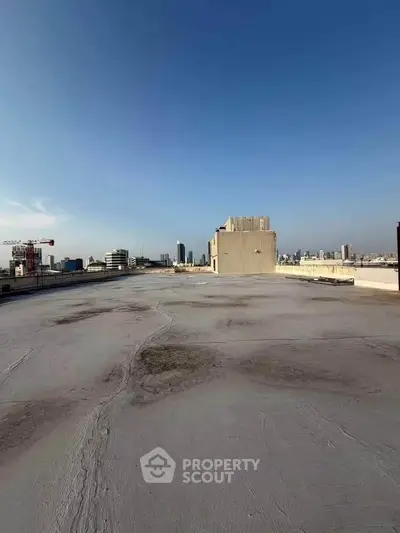 Expansive rooftop view showcasing urban skyline and clear blue sky, ideal for development potential.