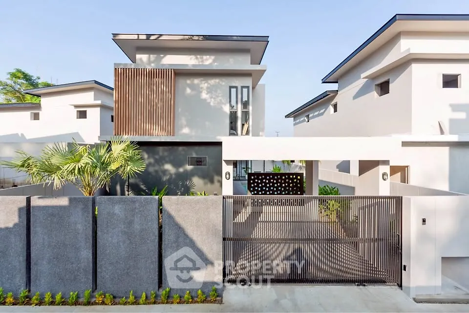 Modern minimalist house exterior with sleek design and gated entrance, showcasing contemporary architecture.