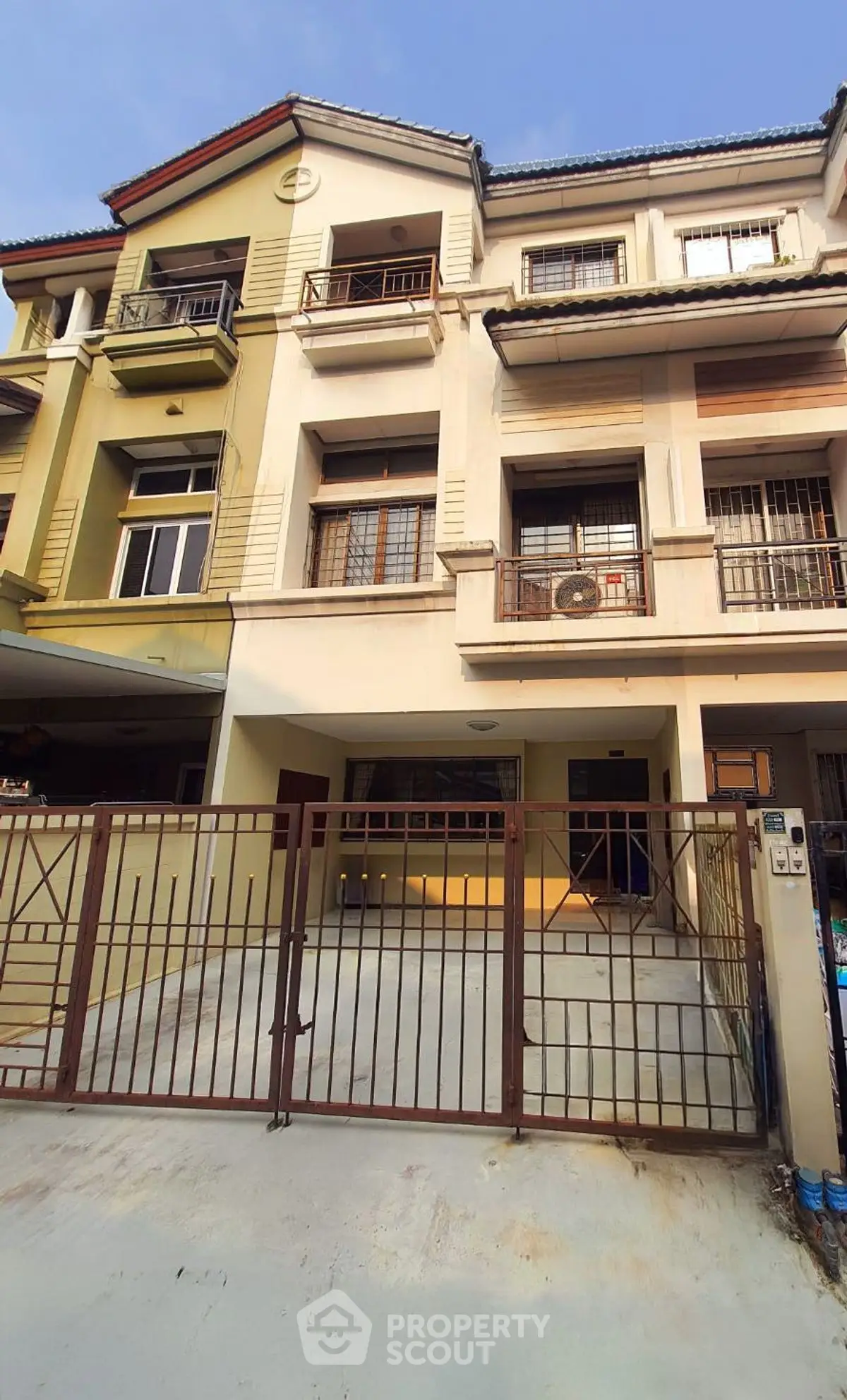 Charming multi-story townhouse with gated driveway and modern facade
