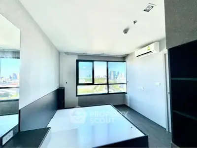 Modern bedroom with large window offering stunning city view