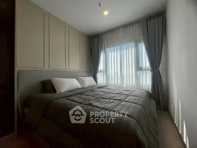 Cozy bedroom with large window and elegant curtains, perfect for relaxation.