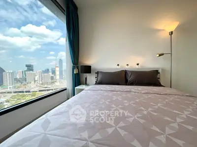 Modern bedroom with city view, featuring large window and stylish decor.