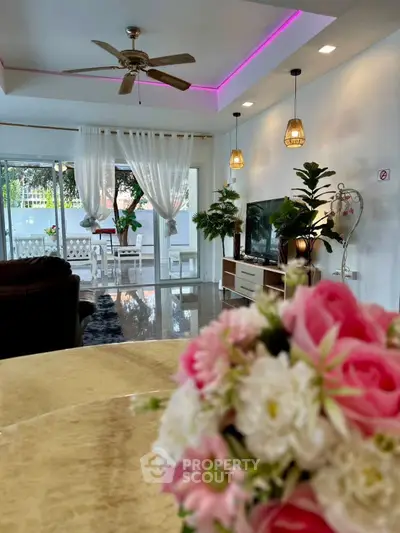 Elegant living room with modern decor and garden view, featuring stylish lighting and cozy seating area.
