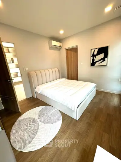 Modern bedroom with stylish decor and wooden flooring