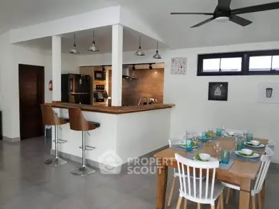 Modern open-plan kitchen and dining area with stylish decor and natural lighting.