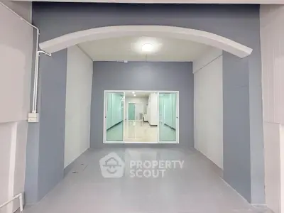 Spacious modern interior with archway and glass doors, ideal for versatile use.