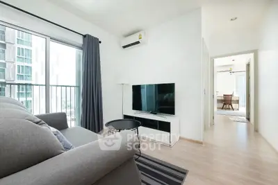 Modern living room with sleek furniture and natural light in a high-rise apartment.