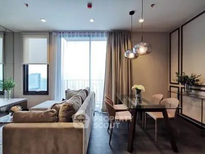 Modern living room with elegant dining area and large windows in a stylish apartment.