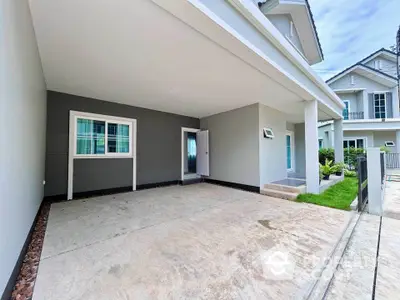 Modern house exterior with spacious driveway and lush green lawn