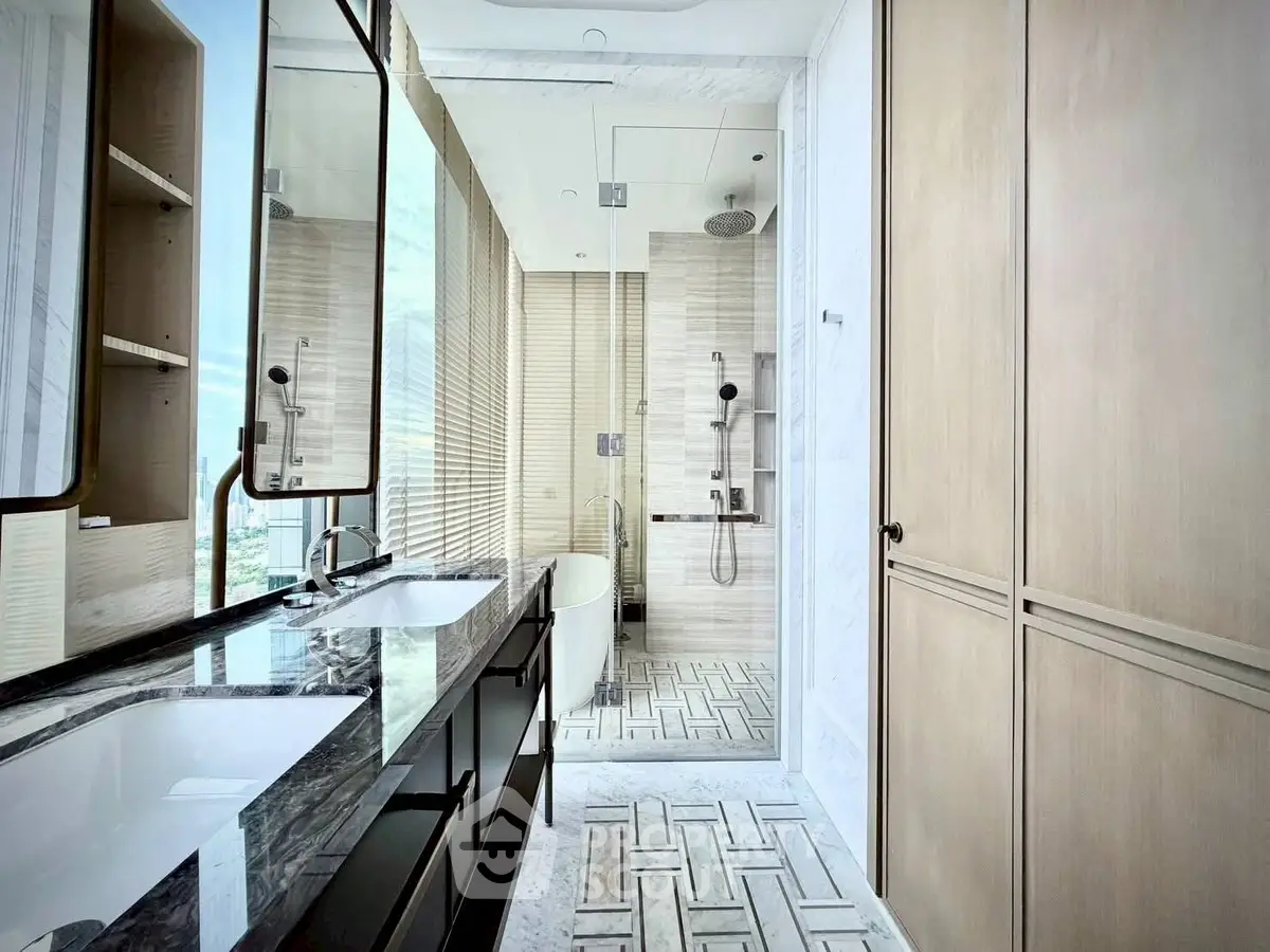 Luxurious modern bathroom with dual sinks, glass shower, and elegant marble finishes.