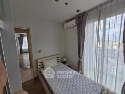 Cozy bedroom with single bed and large window offering city view