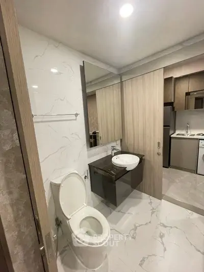 Modern bathroom with sleek design and marble flooring in a contemporary apartment.