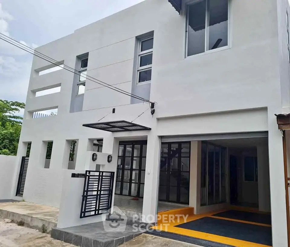 Modern two-story house with sleek design and spacious garage in a serene neighborhood.