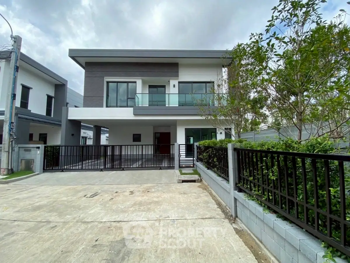 Modern two-story house with spacious driveway and lush greenery
