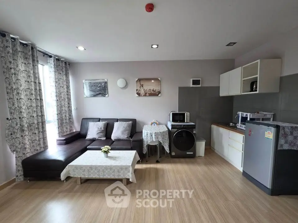 Modern open-layout living room with stylish furniture and kitchen appliances