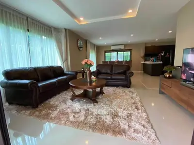Spacious living room with elegant leather sofas and modern decor in a luxurious home.