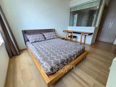 Modern bedroom with wooden flooring and stylish furniture in a bright apartment