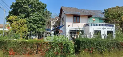 Charming two-story house with lush garden and spacious balcony, perfect for family living.