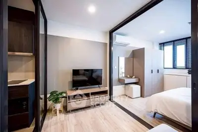 Modern bedroom with sleek design and natural light, featuring a TV and stylish decor.