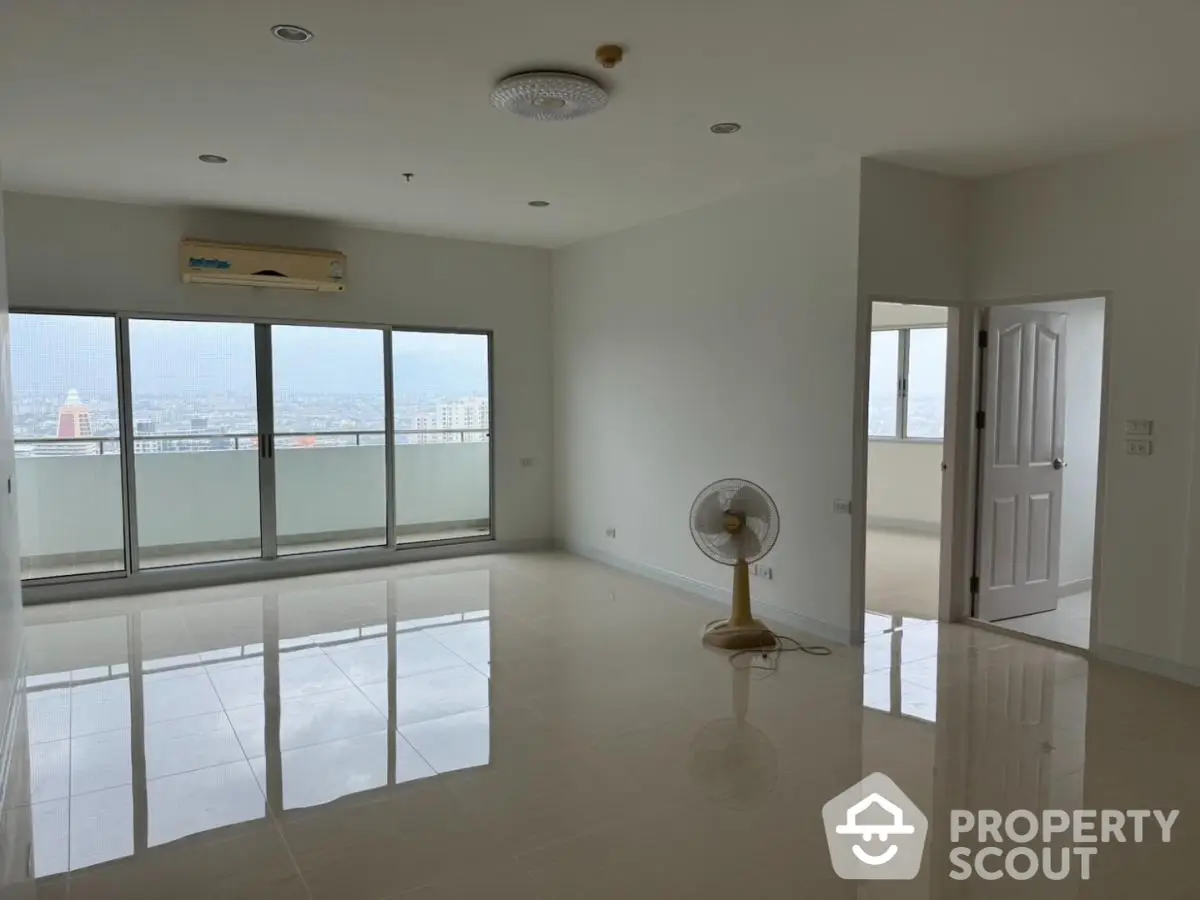 Spacious unfurnished living room with large windows and city view