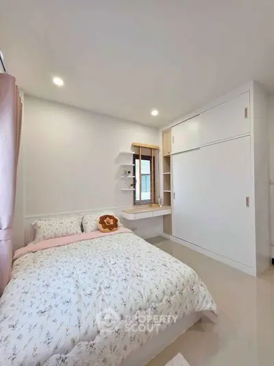 Cozy bedroom with floral bedding and built-in wardrobe