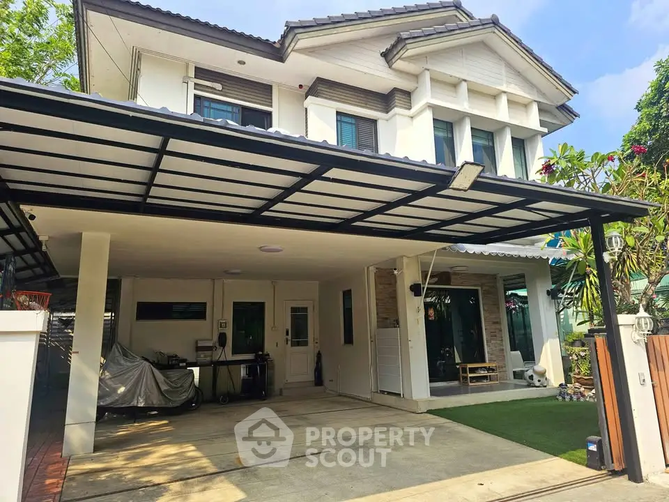 Spacious modern house with covered carport and lush greenery, perfect for family living.