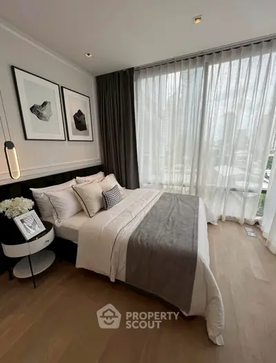 Luxurious bedroom with floor-to-ceiling windows and elegant decor in modern apartment.