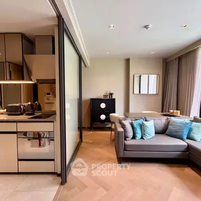Modern living room with open kitchen, stylish decor, and cozy seating area in a contemporary apartment.