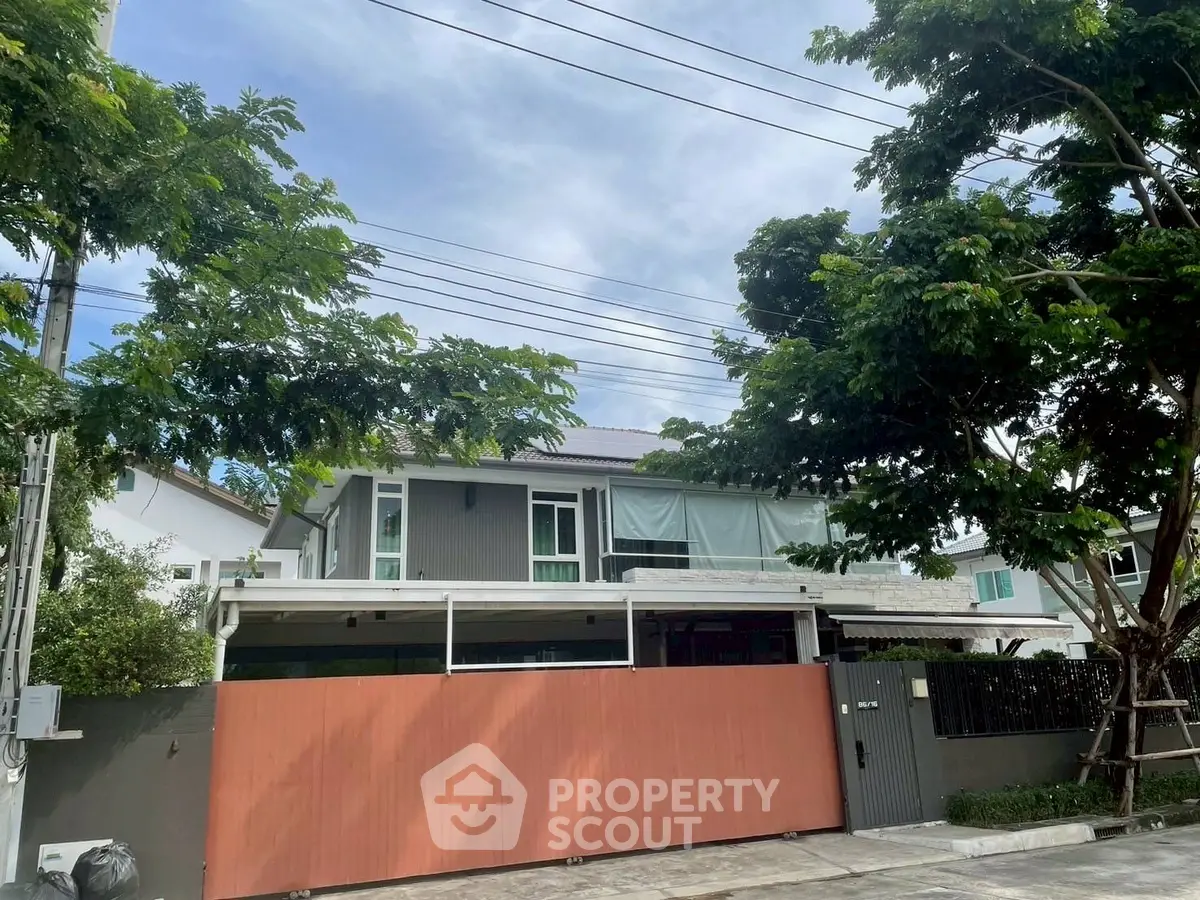Modern two-story house with spacious driveway and lush greenery