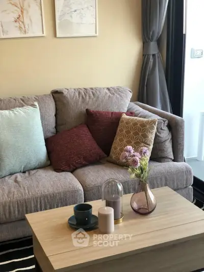 Cozy living room with stylish sofa and decorative cushions, perfect for relaxation.