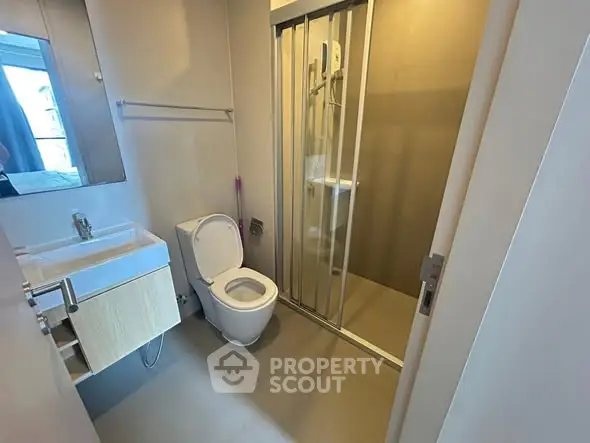 Modern bathroom with sleek fixtures and glass shower enclosure.
