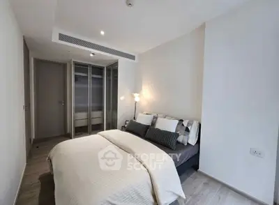 Modern bedroom with stylish decor and ample closet space in a contemporary apartment.