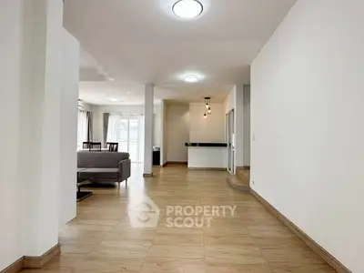 Spacious open-plan living area with modern lighting and wooden flooring