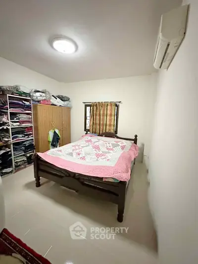 Cozy bedroom with wooden bed and ample storage space, perfect for comfortable living.