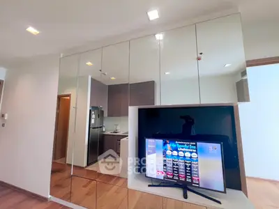Modern living room with sleek mirrored cabinets and built-in TV, showcasing contemporary design and functionality.