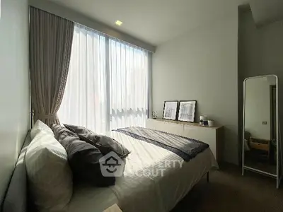 Cozy bedroom with modern decor and large window for natural light