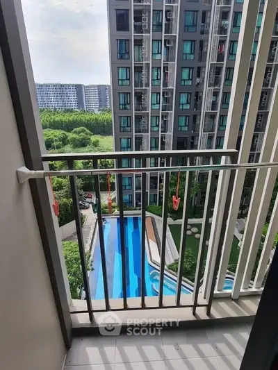 Modern apartment balcony with pool view in urban setting