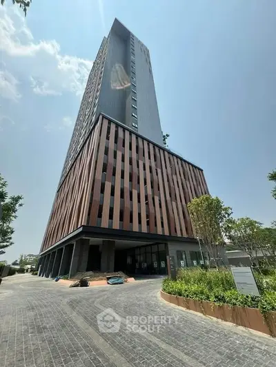 Modern high-rise building with unique facade and landscaped entrance