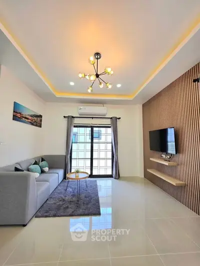 Modern living room with stylish lighting, sleek TV setup, and cozy seating area.