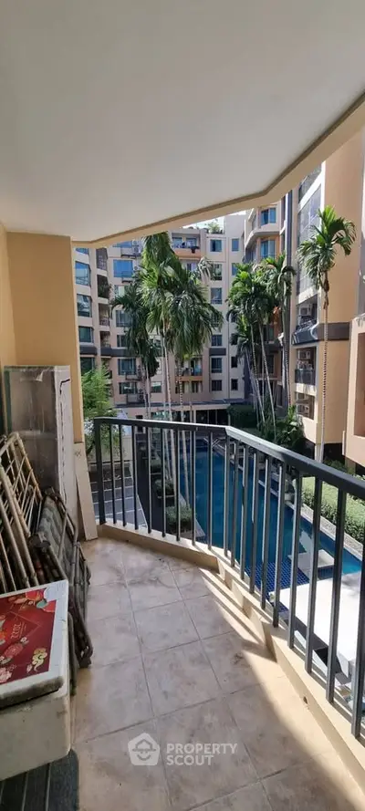 Spacious balcony with pool view in modern apartment complex