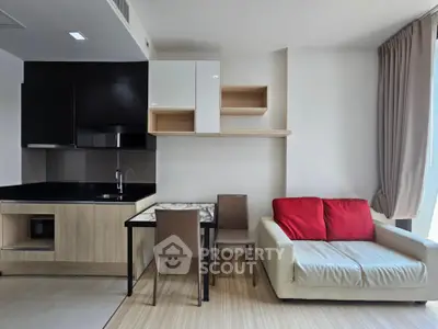 Modern open-layout living room with sleek kitchen and cozy seating area