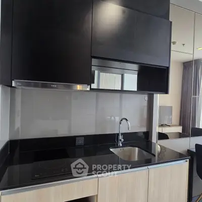 Modern kitchen with sleek black cabinetry and built-in appliances in a stylish apartment.