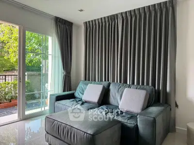 Cozy living room with plush sofa and large window overlooking garden