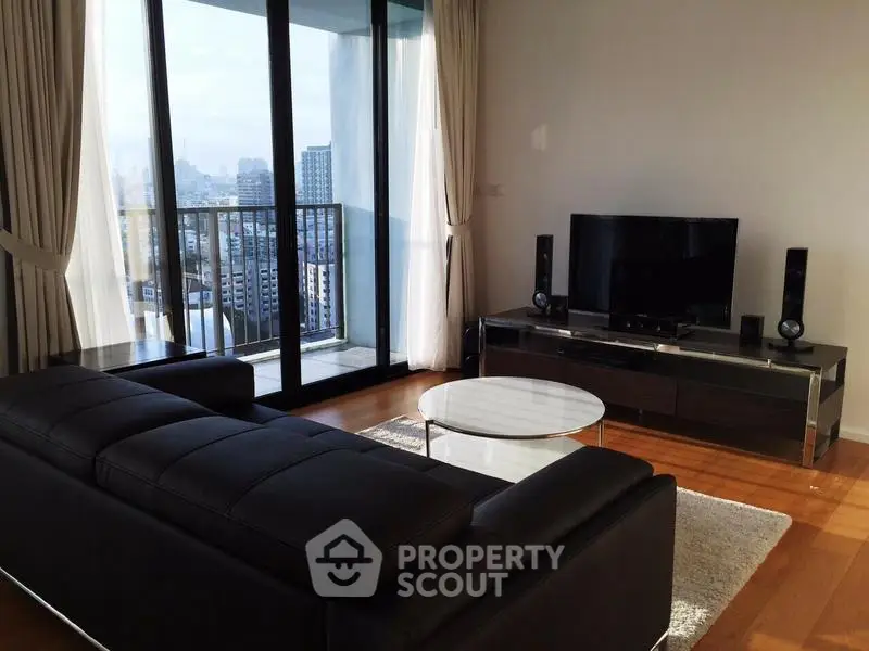 Modern living room with city view and sleek furniture in high-rise apartment.
