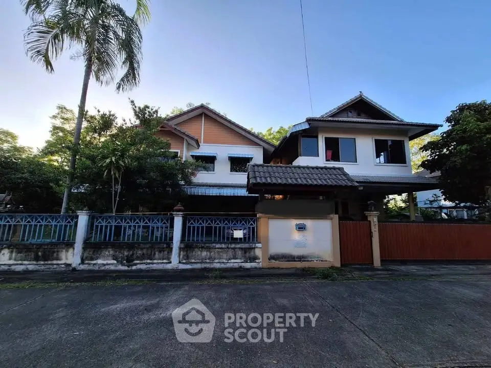 Charming two-story house with lush greenery and spacious driveway in a serene neighborhood.