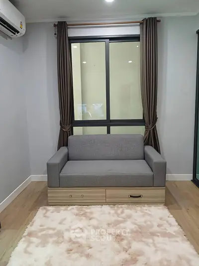 Cozy living room with modern sofa and plush rug, perfect for relaxation.