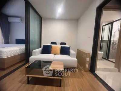 Modern living room with stylish furniture and adjacent bedroom in a contemporary apartment.