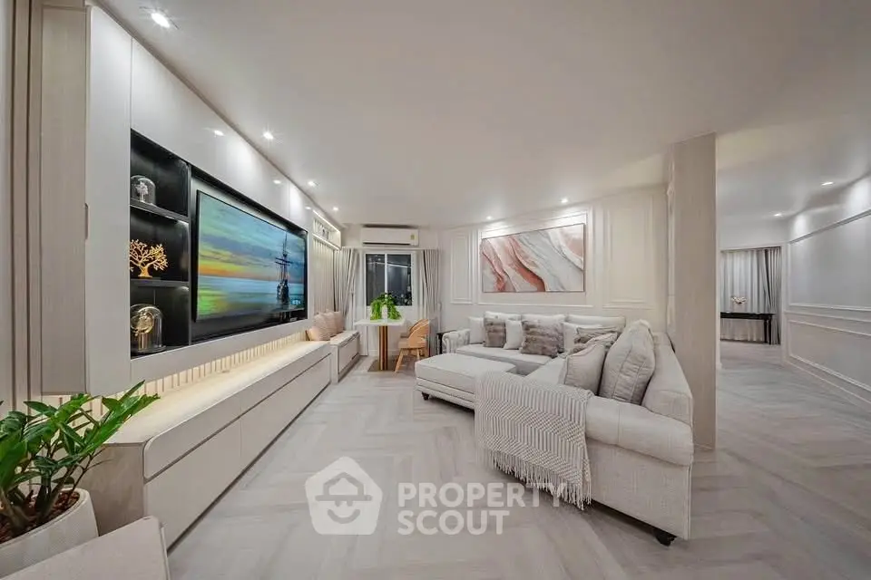 Luxurious modern living room with elegant decor and spacious layout, featuring a large TV and stylish furniture.