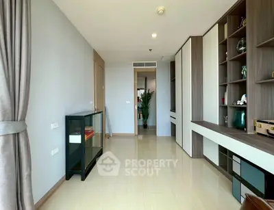Spacious modern living room with elegant built-in shelving and large window for natural light.